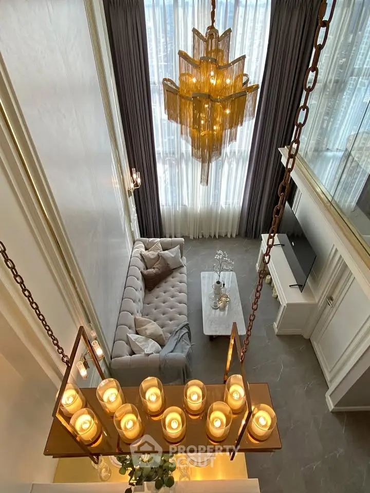 Luxurious high-ceiling living room with elegant chandelier and modern decor