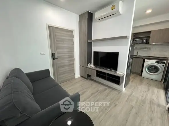 Modern living room with sleek furniture and integrated kitchen appliances.