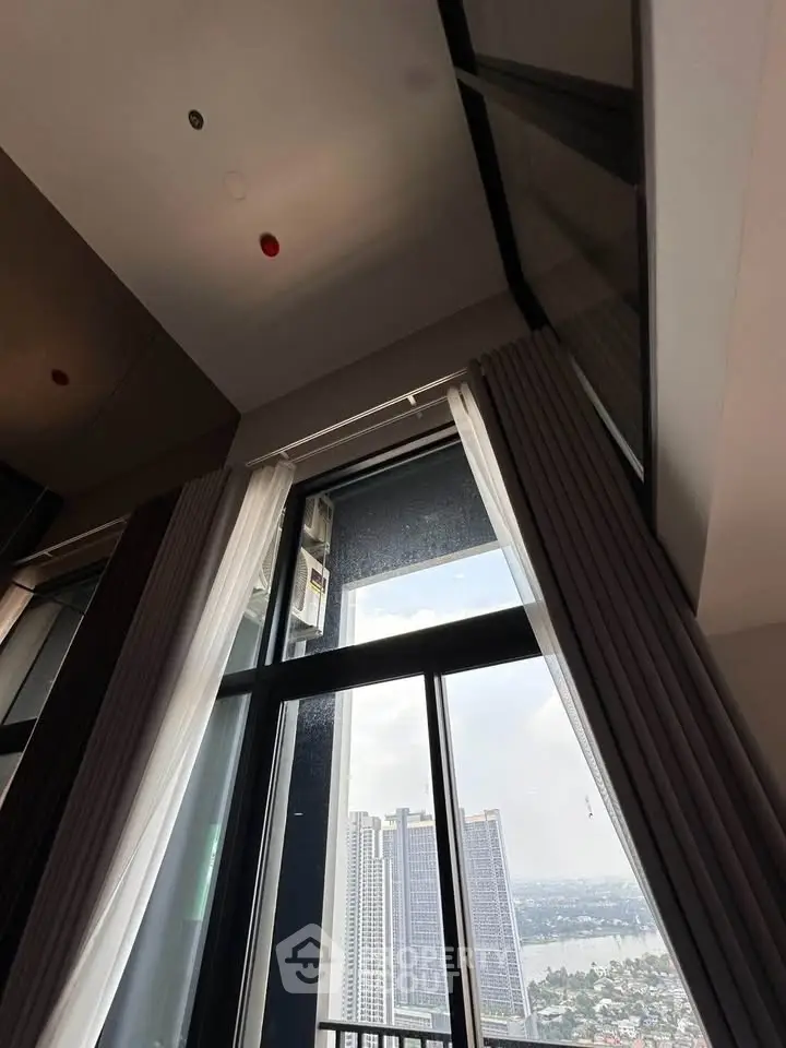 Stunning high-rise apartment view with floor-to-ceiling windows and cityscape backdrop.