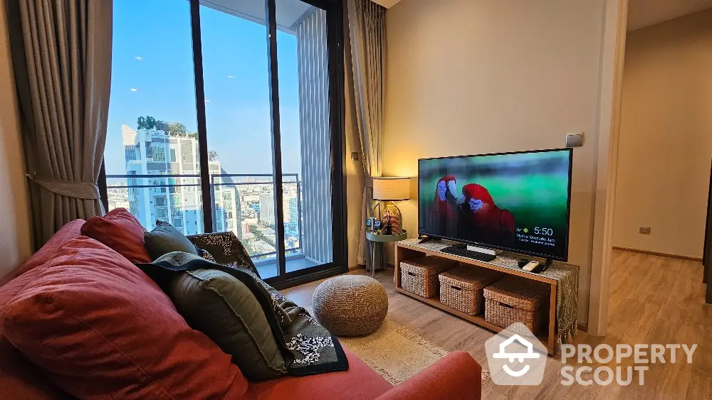 Modern living room with city view and balcony access, featuring cozy seating and stylish decor.