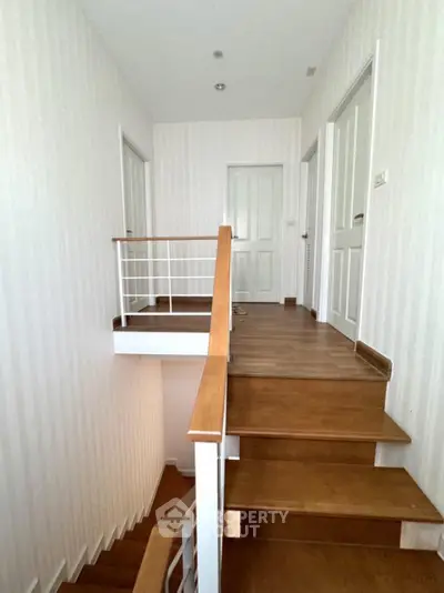 Elegant wooden staircase with modern railing in a bright hallway