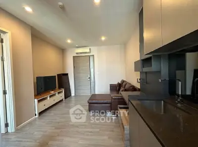 Modern living room with sleek kitchen in open layout, featuring stylish furniture and contemporary design.