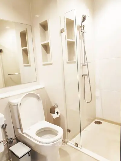 Modern bathroom with glass shower and sleek fixtures in a contemporary home.