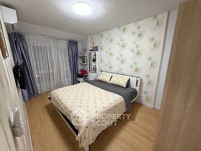 Cozy bedroom with stylish wallpaper and modern furnishings in a well-lit apartment.