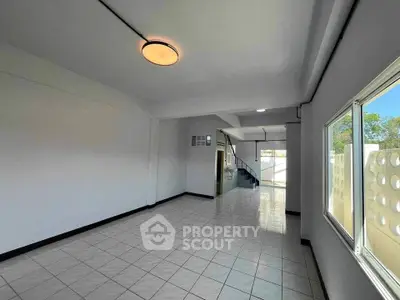 Spacious tiled interior with natural light and modern lighting fixtures