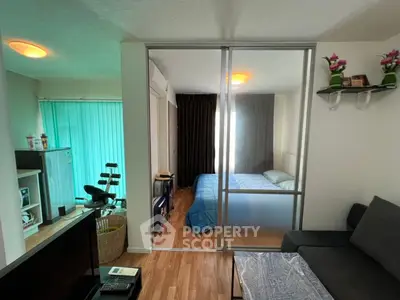 Modern studio apartment with sliding glass partition and cozy living area