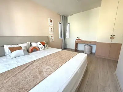 Spacious bedroom with modern decor and natural light, featuring a cozy bed and stylish furniture.