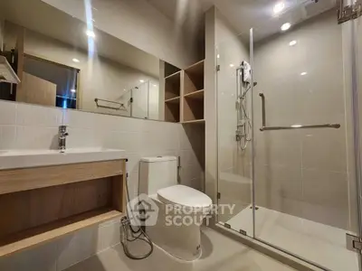 Modern bathroom with glass shower and sleek fixtures in a contemporary apartment.