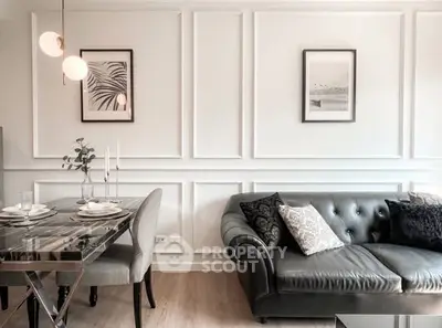 Elegant living room with stylish decor and modern dining area, featuring a chic leather sofa and contemporary lighting.