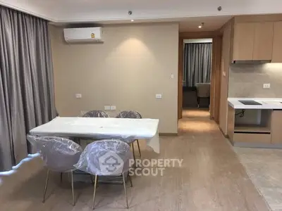 Modern open-layout dining and kitchen area with elegant furnishings and neutral tones.