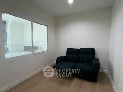 Cozy small room with a black recliner sofa and wooden flooring
