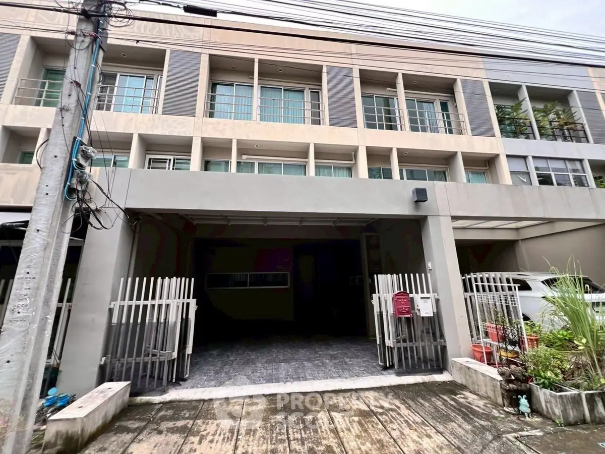 Modern townhouse exterior with gated entrance and large windows