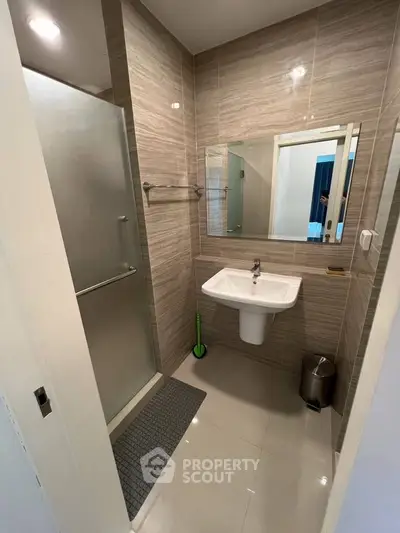 Modern bathroom with sleek design, featuring a glass shower enclosure and stylish sink.