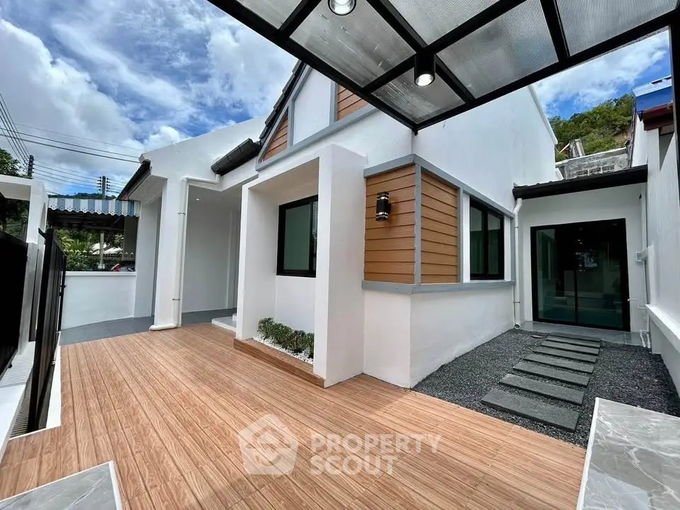 Modern white house exterior with wooden accents and covered patio, showcasing sleek design and inviting outdoor space.