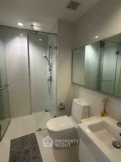 Modern bathroom with glass shower and sleek fixtures in a contemporary home.