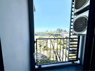 Stunning cityscape view from a modern balcony with air conditioning units.