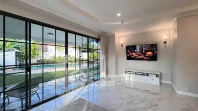 Spacious living room with pool view and modern decor, perfect for relaxation and entertainment.