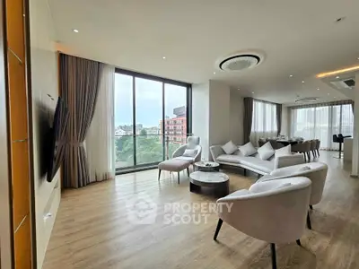 Spacious modern living room with large windows and elegant furnishings, offering a stunning city view.