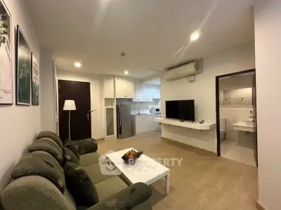 Modern living room with open kitchen and cozy seating area in a stylish apartment.