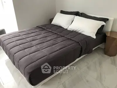 Modern bedroom with sleek design and cozy bedding in a stylish real estate property.