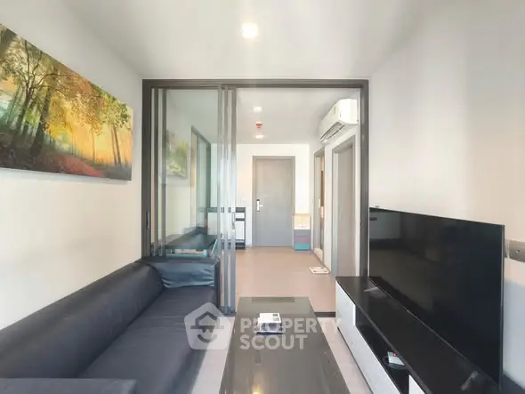 Modern living room with sleek furniture and large TV, perfect for relaxation and entertainment.