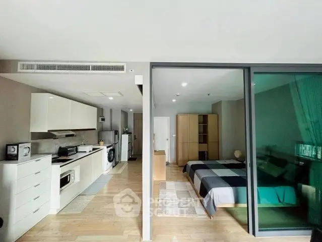 Modern open-plan apartment with sleek kitchen and cozy bedroom