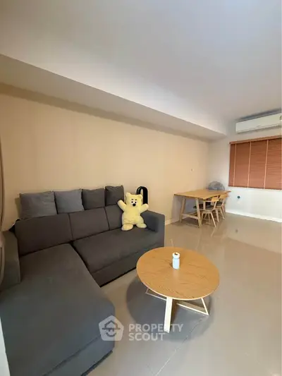 Modern living room with cozy gray sofa and stylish wooden table, perfect for relaxation and entertaining.