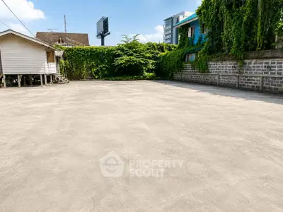 Spacious outdoor area with lush greenery and urban backdrop, ideal for development opportunities.