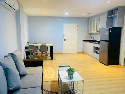 Modern open-plan living room and kitchen with stylish decor and wooden flooring.