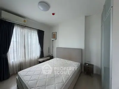 Spacious bedroom with natural light and modern furnishings in a stylish apartment.