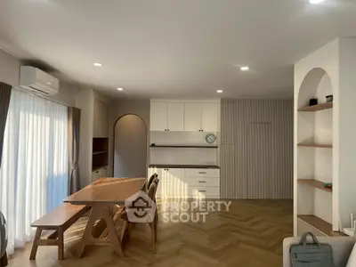Spacious modern living room with elegant wooden dining set and natural light.