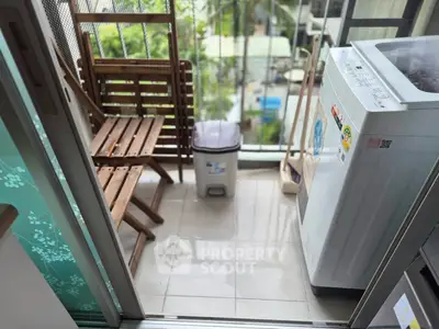 Charming balcony with washing machine and seating area, perfect for urban living convenience.