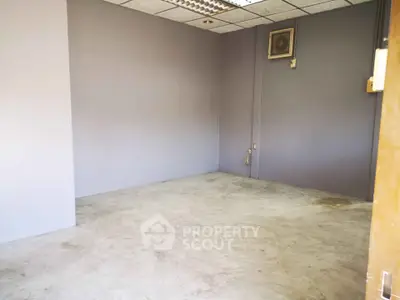 Spacious empty room with concrete floor and neutral walls, ideal for customization.