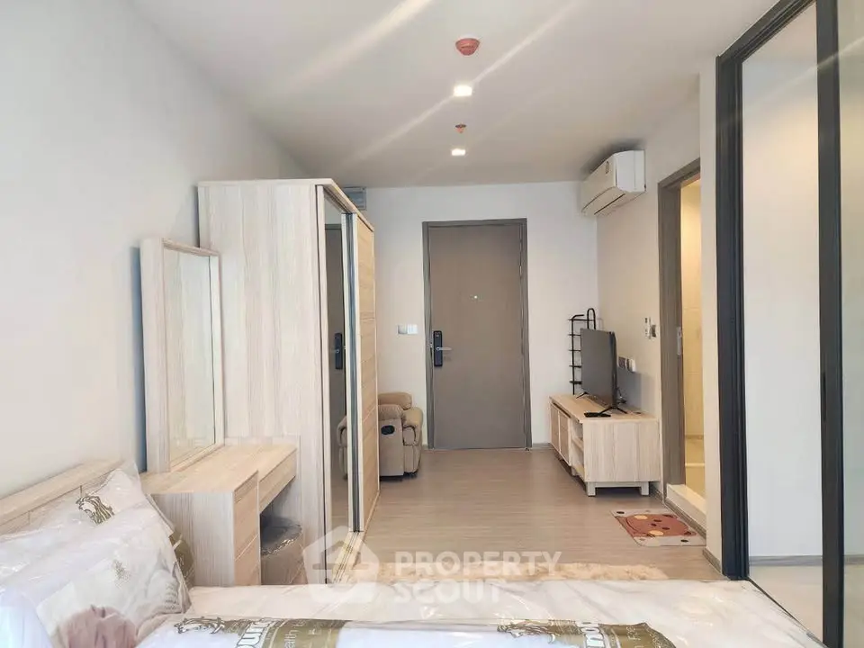 Modern bedroom with sleek furniture and neutral tones, featuring a cozy bed and stylish wardrobe.