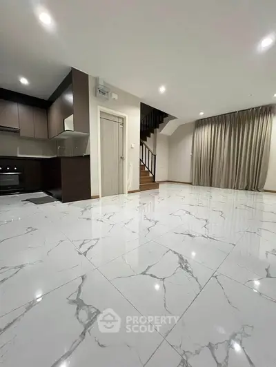 Spacious modern living room with marble flooring and open kitchen layout