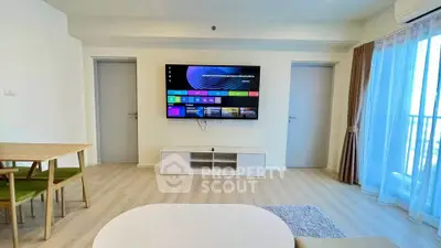 Modern living room with wall-mounted TV and balcony view, featuring stylish furniture and natural light.