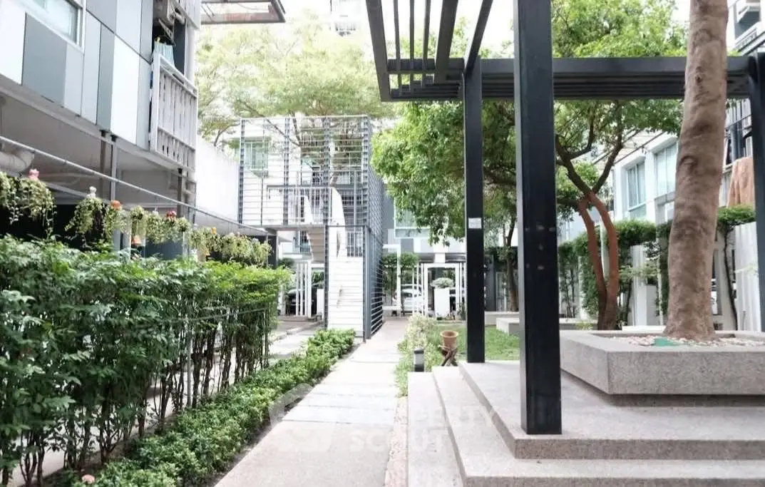 Modern apartment complex with lush greenery and contemporary design.