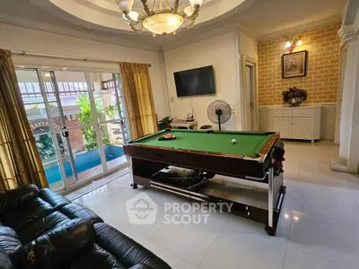 Stylish living room with pool table and elegant decor, perfect for entertainment and relaxation.
