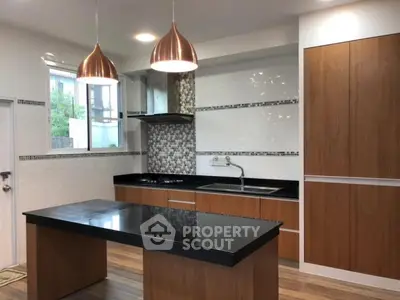 Modern kitchen with sleek black countertops and stylish pendant lighting