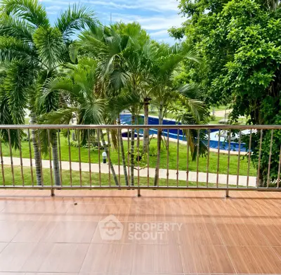 Spacious balcony with lush garden view and palm trees, perfect for relaxation.