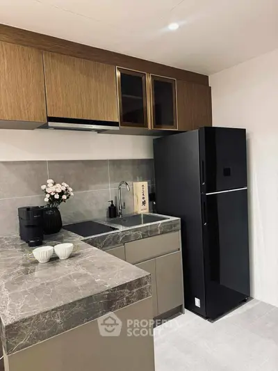 Modern kitchen with sleek black fridge and elegant marble countertops