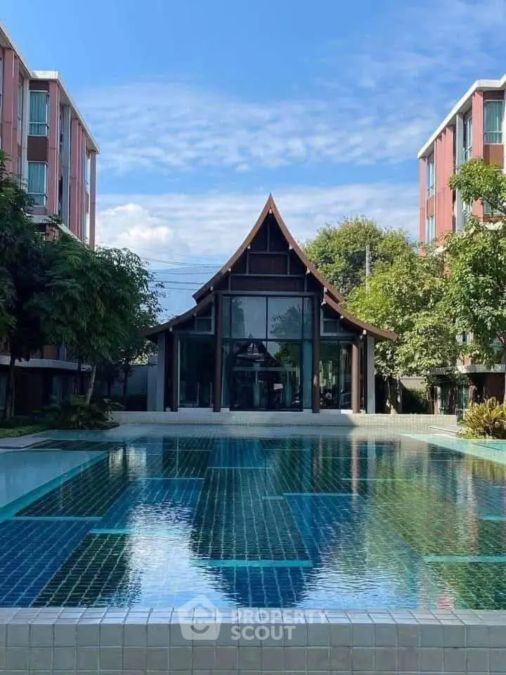 Stunning modern building with a luxurious pool and lush greenery, perfect for upscale living.