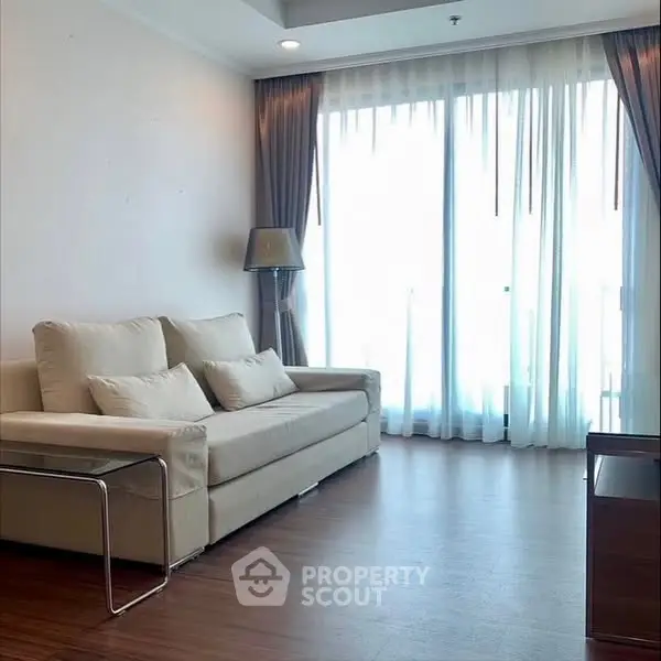 Spacious living room with elegant sofa and floor-to-ceiling windows.