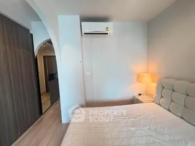 Cozy bedroom with modern air conditioning and soft lighting, featuring a comfortable bed and stylish decor.