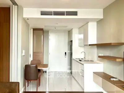 Modern kitchen with sleek white cabinetry and integrated dining area in a stylish apartment.