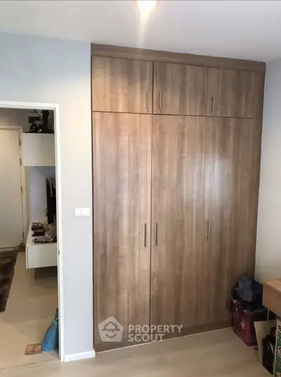 Spacious bedroom with built-in wooden wardrobe and modern decor
