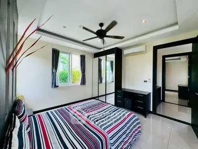 Spacious bedroom with modern decor and large mirrored wardrobe