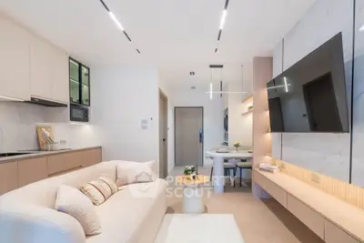 Modern living room with sleek design, featuring a large wall-mounted TV, cozy sofa, and elegant dining area.