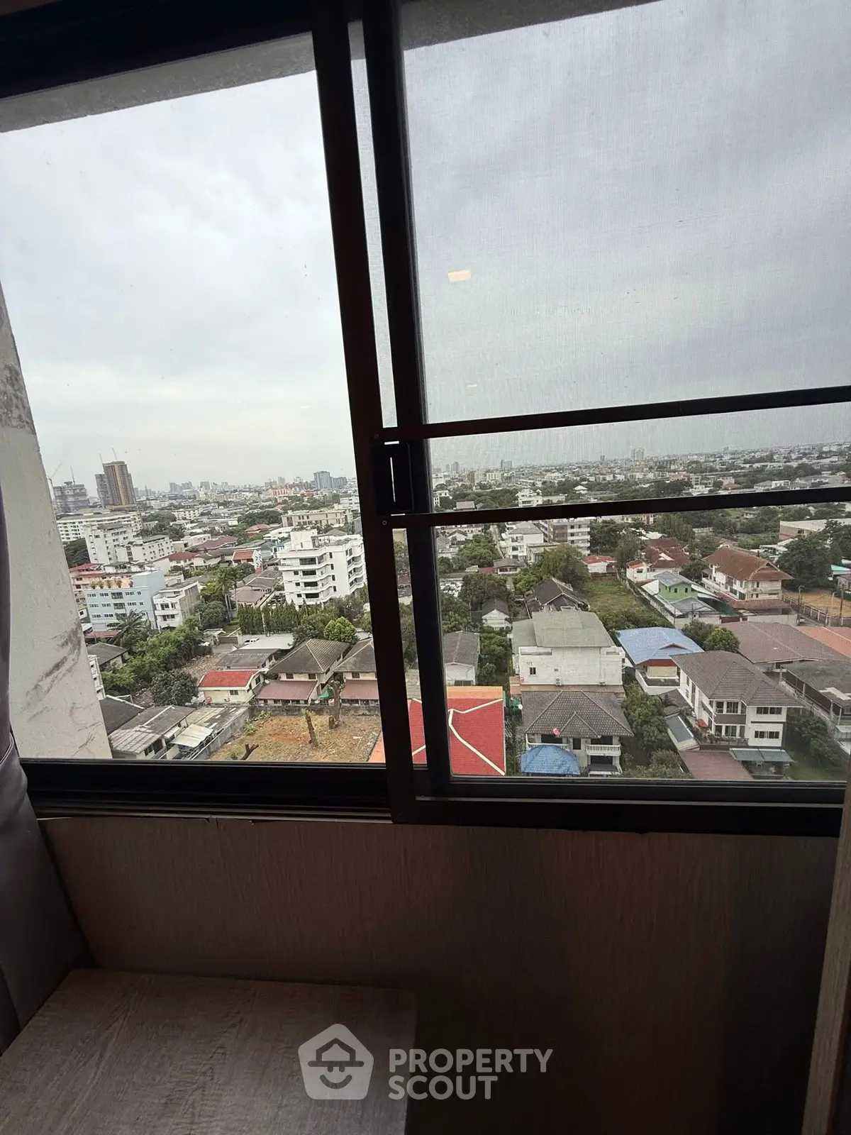 Stunning cityscape view from high-rise apartment window showcasing urban living.