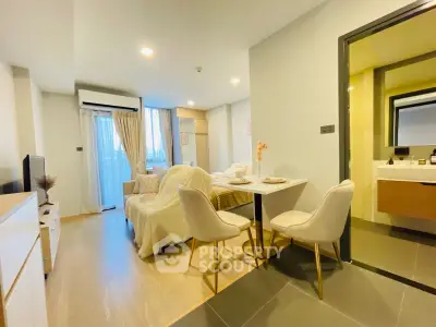 Modern open-plan living room with dining area and cozy decor in a stylish apartment.